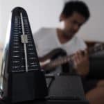 Black metronome is used by musician to help keep a steady tempo as he play